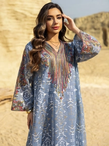 Détail du caftan ethnique bleu avec broderie complexe à l'encolure et glands décoratifs
