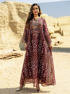 Detail of dark red kaftan maxi dress with ethnic embroidery and geometric patterns
