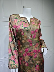 Detailed close-up of floral print dress with golden beadwork on the V-neck and cuffs
