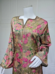 Detail of floral printed dress featuring gold sequin trim on V-neck and sleeves