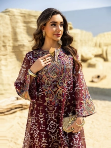 Close-up of intricate ethnic floral embroidery on a burgundy mesh maxi dress