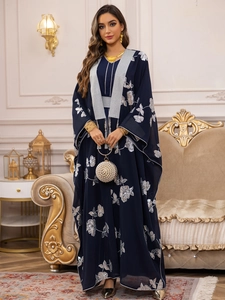 Détail d'un caftan bleu marine avec broderie florale argentée et pompons à paillettes