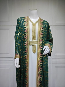 Détail du caftan vert avec motifs de feuilles dorées et broderies de glands colorés