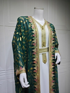 Détail du caftan en mousseline verte avec motifs plumes dorées et broderies à franges