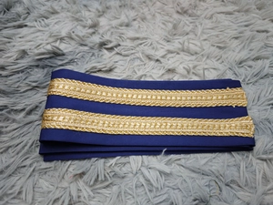 Nahaufnahme eines dunkelblauen Stoffbands mit doppelten goldfarbenen Stickereidetails