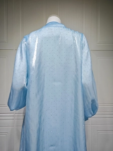 Close-up of light blue satin gown featuring shimmering rhinestones and puffed sleeves