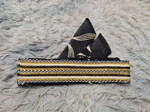 Close-up of black and gold embroidered ethnic headpiece with traditional folding pattern