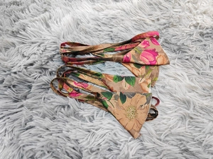 Flat lay of floral bikini top and headscarf set with brown and pink retro patterns