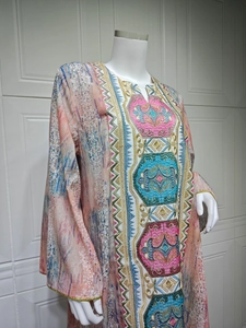 Détail de la robe caftan rose avec broderie ethnique bleue et bordure dorée