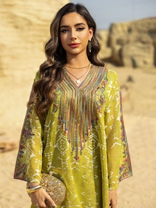 Détail de robe de soirée vert citron avec broderies colorées et pompons en perles
