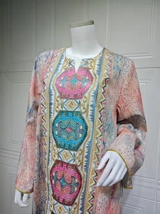 Gros plan détaillé des broderies complexes sur l'encolure en V de la robe caftan