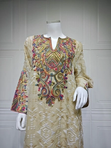 Close-up of colorful ethnic embroidery and sequins on the V-neck mesh dress bodice