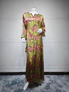 Detail of green floral maxi dress featuring pink blossom patterns and soft silky fabric
