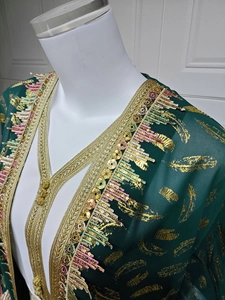 Détail du cardigan en mousseline vert foncé avec plumes dorées et broderies de sequins