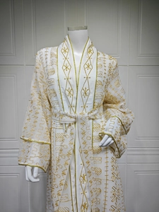 Détail de la robe élégante en tulle blanc avec broderie dorée et texture de tissu luxueux