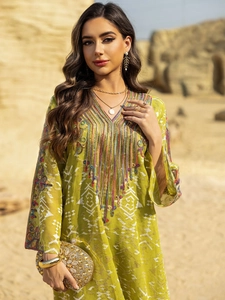 Détail de broderies ethniques colorées sur l'encolure d'une robe caftan verte