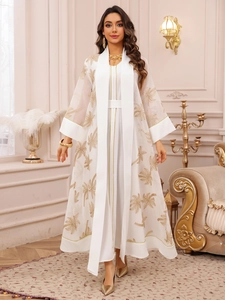 Detail view of gold palm tree embroidery and trim on white tulle modest dress