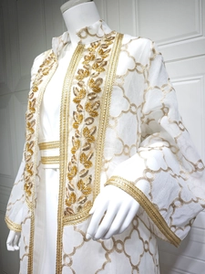 Detailansicht der goldener Blumenstickerei und Pailletten auf weißen Kaftan-Ärmeln