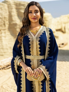 Detail of navy blue chiffon kaftan dress with intricate gold embroidery and woven belt