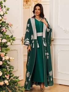 Détail du caftan vert foncé avec broderies florales argentées et détails de franges