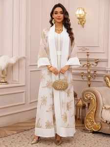 Close-up of elegant gold palm tree embroidery on a white long-sleeved mesh cardigan