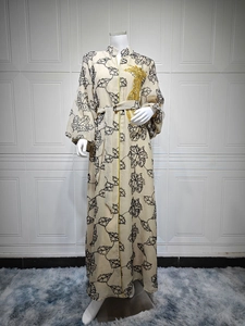 Close-up of golden phoenix embroidery on beige Jalabiya dress with black leaf patterns