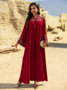 Detail of red Middle Eastern abaya featuring intricate floral embroidery and gold buttons