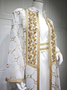 Detail eines weißen Kaftan-Sets mit goldener Blatt-Paillettenstickerei und Kleeblattmuster