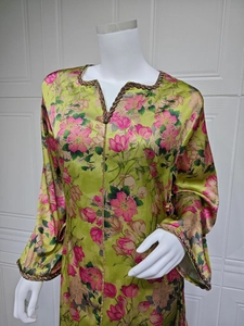 Close-up of V-neckline with brown bead trim on a floral print satin kaftan dress
