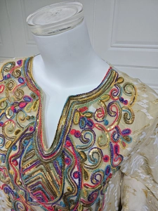 Detail view of ethnic kaftan top featuring gold thread embroidery and multi-color sequins