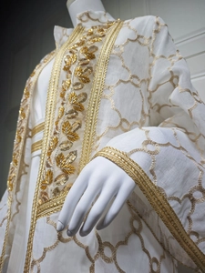 Detail eines weißen Kaftans mit Goldstickerei und handgenähten Pailletten an den Ärmeln