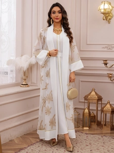 Detail of white abaya set featuring golden palm tree embroidery and elegant sequins