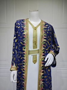 Détails des motifs de plumes dorées et broderie à franges sur le cardigan en mousseline