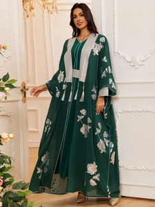 Détail de broderies florales argentées et glands sur cet ensemble abaya vert foncé