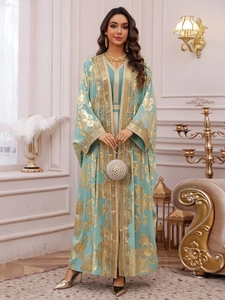 Detail of teal Moroccan kaftan with gold floral embroidery and pearl evening bag