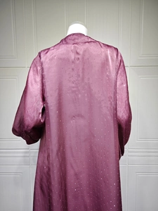 Close-up of purple satin long robe featuring white sequins and puff sleeves detail
