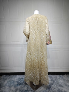 Detail showing floor-length kaftan with geometric embroidery and floral cuffs