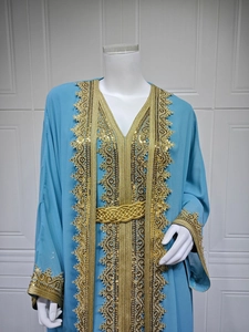 Macro detail of sky blue chiffon kaftan with gold sequin embroidery and woven belt