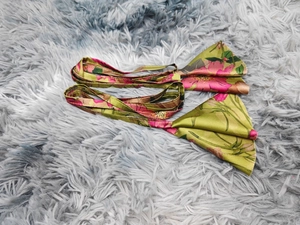 Detail of green floral print headbands with smooth fabric on a soft textured background