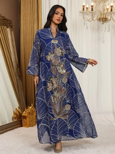 Vista dettagliata di un abito in mesh blu con ricami floreali ed eleganti paillettes.