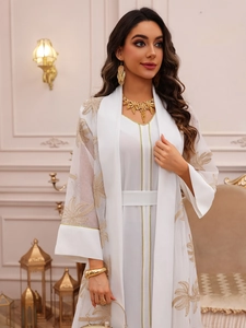 Detail of elegant white long robe with gold leaf embroidery and sheer cardigan