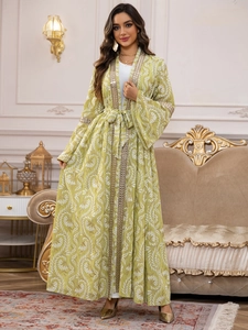 Dettaglio del caftan verde floreale con ricami di perline dorate su scollo e maniche