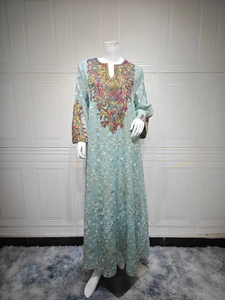 Detail of colorful embroidery on the neckline and cuffs of a light blue kaftan dress