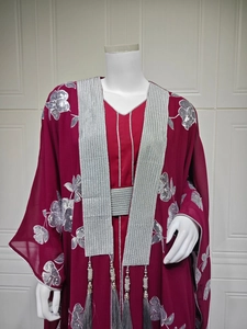 Détail du caftan bordeaux avec broderies argentées, paillettes et châle à franges