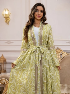 Dettaglio di caftano floreale verde con paillettes dorate e ricami a specchio a mano