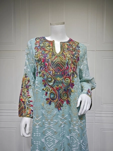 Detailed close-up of bohemian light blue top with colorful embroidery and sequins