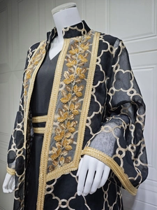 Detailansicht der aufwendigen Goldstickerei und Luxus-Perlenstickerei auf schwarzem Abaya-Stoff