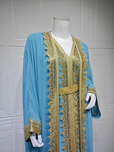 Detailed close-up of intricate gold embroidery and sequins on light blue chiffon dress