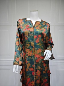 Detail of V-neckline and metallic braided trim on green floral satin kaftan dress