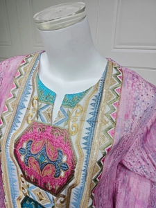 Détail de la broderie complexe et des paillettes sur le col en V de la robe rose